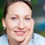 Close-up of a smiling woman with clear, healthy skin, representing hormone therapy results timeline and expectations, including how long hormone therapy takes to work and when HRT benefits become noticeable. Treatments offered at Greenwich Medical Spa.